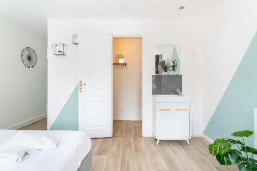 a bedroom with a white bed and a white door at S&K Suite Grande rue Roubaix - Chambre spacieuse et SDB privée - Netflix et Cuisine in Roubaix