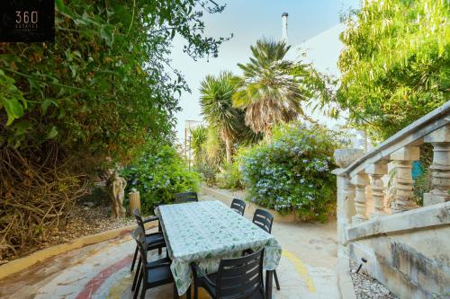un tavolo e sedie seduti accanto a una recinzione di Spacious Villa with Private Pool & BBQ in St'Pauls by 360 Estates a San Pawl il-Baħar
