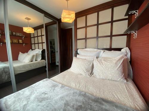 1 dormitorio con cama y espejo grande en Apartamento caracol, en Los Abrigos