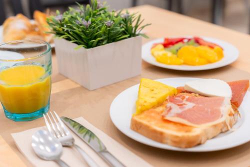 a table with two plates of food and a glass of orange juice at La City Mercado in Alicante