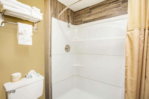 y baño con aseo y ducha. en Super 8 by Wyndham Redlands/San Bernardino, en Redlands
