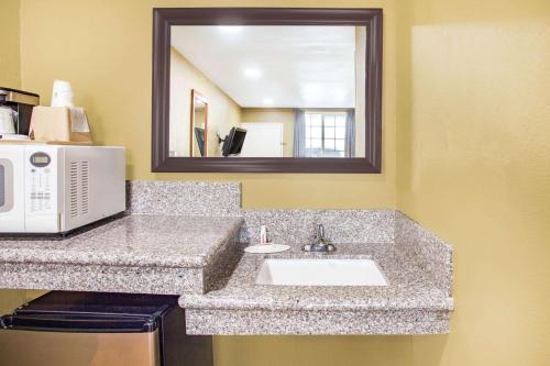 a bathroom counter with a sink and a microwave at Super 8 by Wyndham Redlands/San Bernardino in Redlands