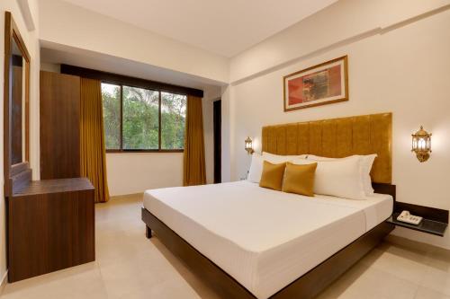 a bedroom with a large bed and a window at Lemon Tree Hotel, Dapoli in Dapoli