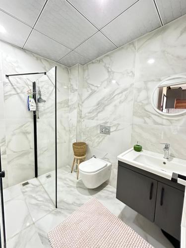 uma casa de banho branca com um WC e um lavatório em Yeni denize yakın minimalist evler em Mersin