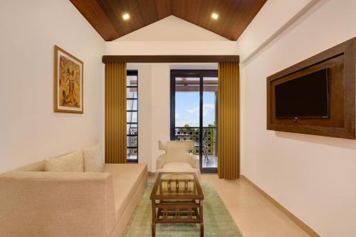 a living room with a tv and a couch at Lemon Tree Hotel, Dapoli in Dapoli