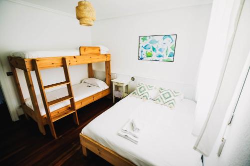 a bedroom with two bunk beds and a ladder at Loredo Surf House in Loredo