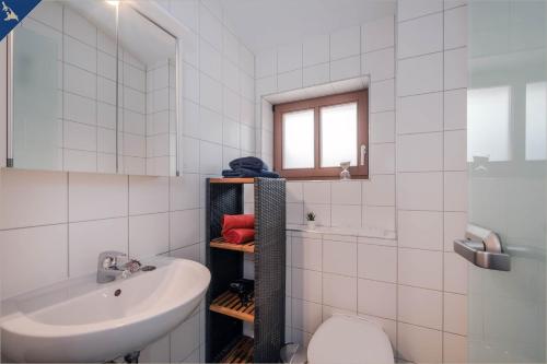 Baño blanco con lavabo y aseo en Villa Luna Ferienwohnung Achterdeck, en Ahlbeck