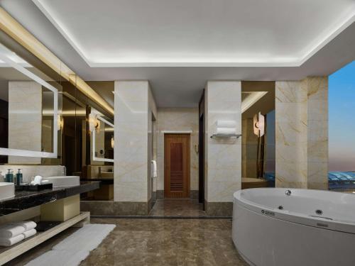 y baño con bañera y lavamanos. en Hilton Beijing Capital Airport en Shunyi