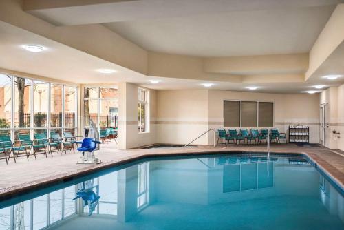 una piscina con sedie e tavoli in una camera d'albergo di Hilton Garden Inn Atlanta South-McDonough a McDonough