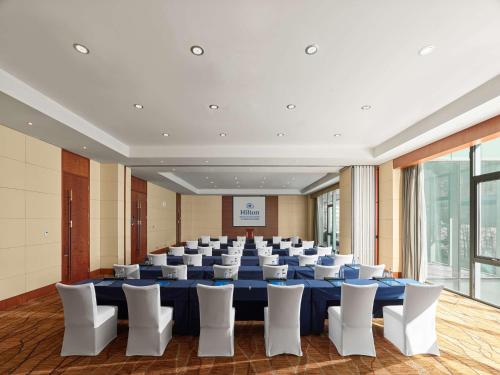 a conference room with a large blue table and white chairs at Hilton Beijing Capital Airport in Shunyi