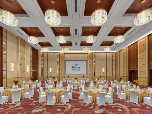 a banquet hall with tables and chairs in a room with chandeliers at Hilton Beijing Capital Airport in Shunyi