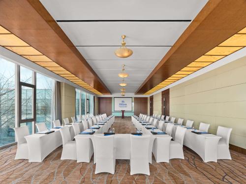 a conference room with white chairs and a podium at Hilton Beijing Capital Airport in Shunyi