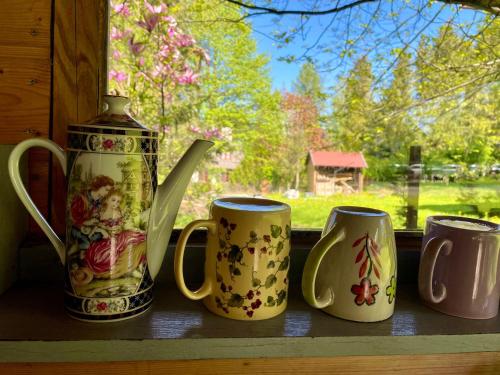 a group of four coffee mugs sitting on a window sill at Pod Berdem in Wetlina