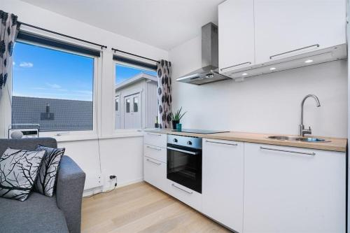uma cozinha com armários brancos e uma grande janela em Apartment in Lillestrøm with free parking and great view em Lillestrøm