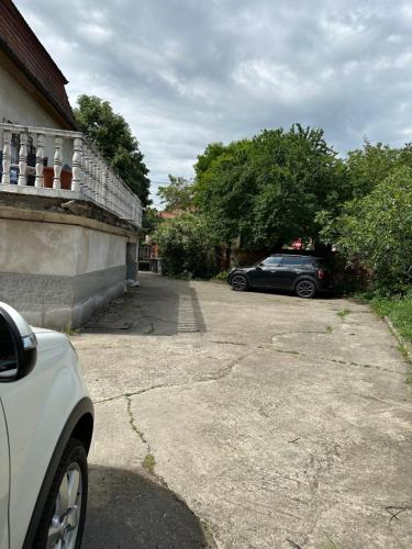 a car parked in a driveway next to a building at Mosaico Alfetta Hostel in Timişoara