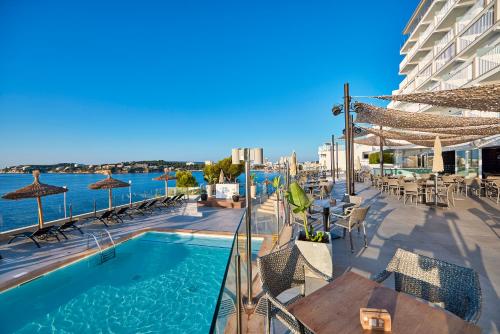 a swimming pool with chairs and tables and a building at Hotel Florida Magaluf - Adults Only in Magaluf