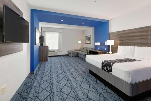 a hotel room with a large bed and a television at La Quinta by Wyndham Denton - University Drive in Denton