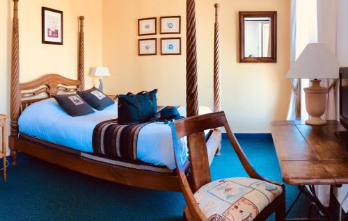 um quarto com uma cama e uma cadeira de madeira em Hôtel-Restaurant Côté Rivage em Badefols-sur-Dordogne