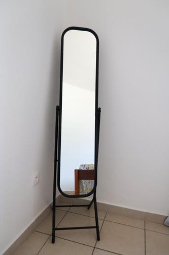 a mirror with a black frame against a white wall at Mana 45 A in Mana