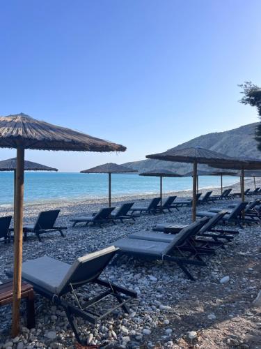 a group of lounge chairs and umbrellas on a beach at Matteo Villa Limassol Cyprus in Limassol