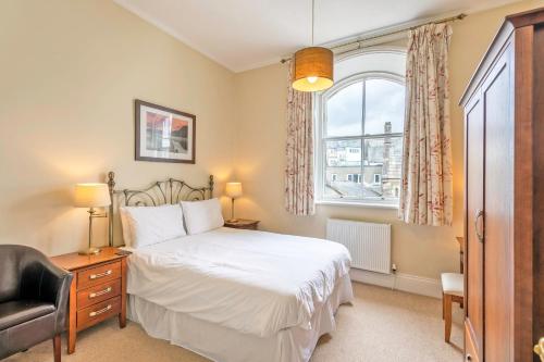 a bedroom with a bed and a chair and a window at Keswick View in Keswick