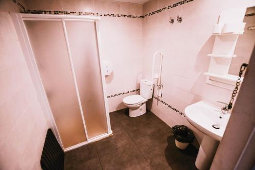 a bathroom with a shower and a toilet and a sink at Loredo Surf House in Loredo