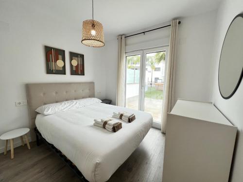 1 dormitorio con 1 cama con 2 toallas en PUSHE Playa Granada Beach & Golf 28, en Motril