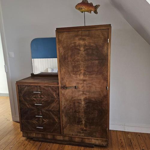 a wooden cabinet with a wooden door in a room at Charmante maison bretonne vue mer proche des plus belles plages in Landéda