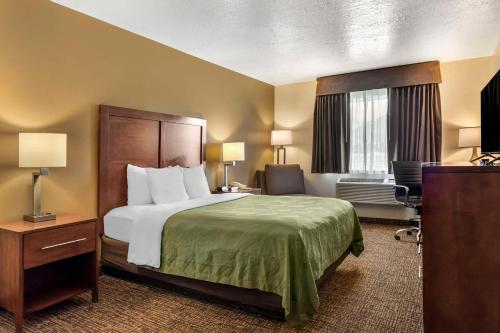 Quality Inn Logan near University في لوجان: غرفة الفندق بسرير كبير ومكتب