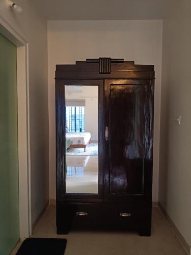 a wooden cabinet with a mirror in a room at Nagarik Commune, Baner - Pune in Pune