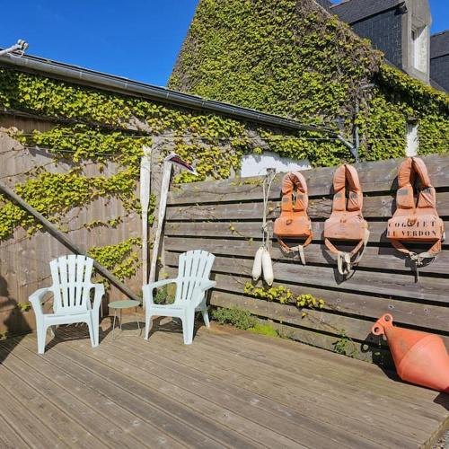 a pair of shoes hanging on a wooden bench at Charmante maison bretonne vue mer proche des plus belles plages in Landéda