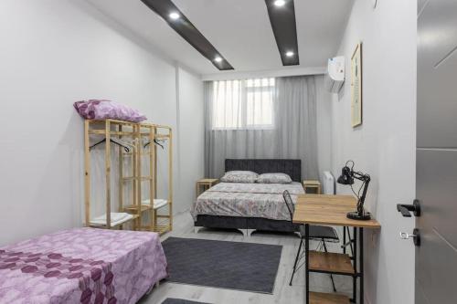 a bedroom with two beds and a table and a desk at 4-3 Yatak Odalı Büyük Daire Kaleiçi Yakını in Antalya