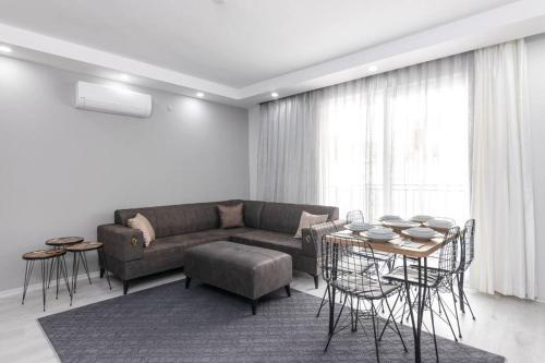 a living room with a couch and a table and chairs at 4-3 Yatak Odalı Büyük Daire Kaleiçi Yakını in Antalya