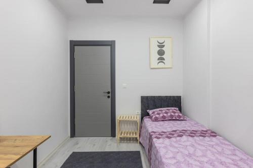 a bedroom with a bed and a table and a door at 4-3 Yatak Odalı Büyük Daire Kaleiçi Yakını in Antalya