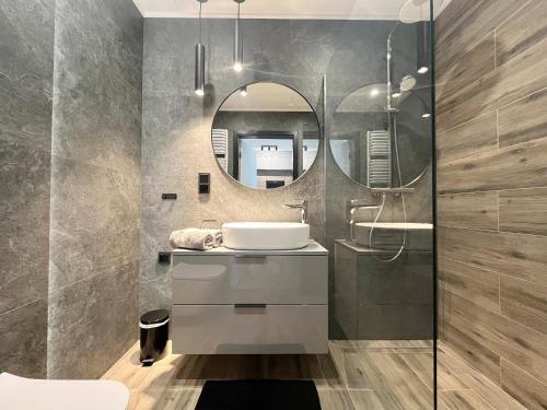 a bathroom with a sink and a mirror at Shellter Prestige Przy Wydmie in Rogowo