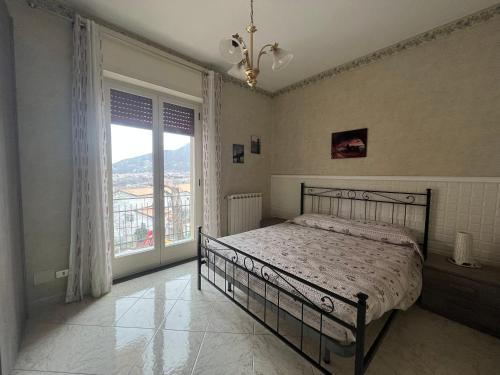 um quarto com uma cama e uma grande janela em La dimora di zeus em Agerola