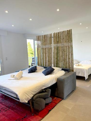 - une grande chambre avec un grand lit et une grande fenêtre dans l'établissement Le Cèdre Magnifique Appartement à Cannes, à Cannes