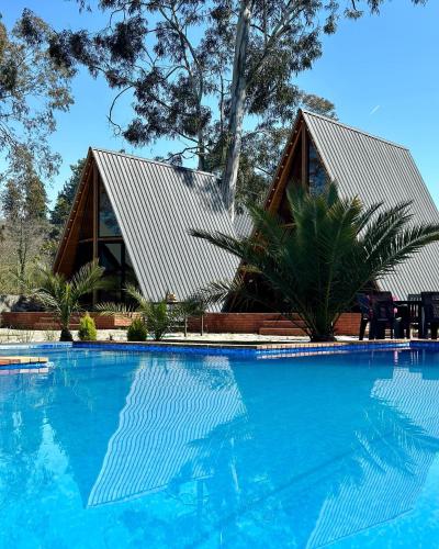 a house with a swimming pool in front of it at Eucalyptus Cottages in Chakvi