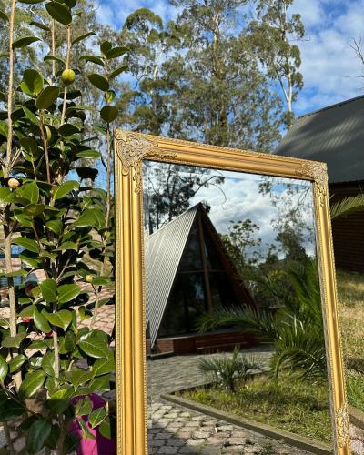 a mirror with a tent in the reflection at Eucalyptus Cottages in Chakvi