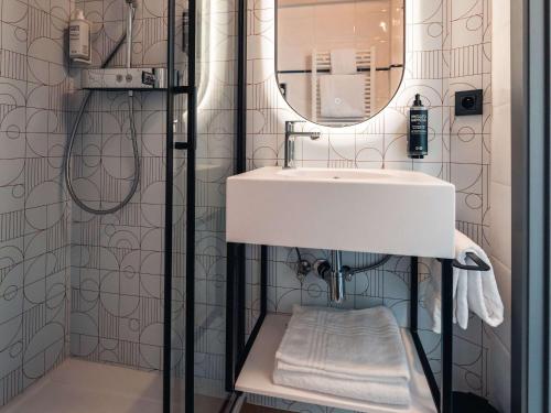 W łazience znajduje się umywalka i lustro. w obiekcie Aero44 Hotel Charleroi Airport w Charleroi