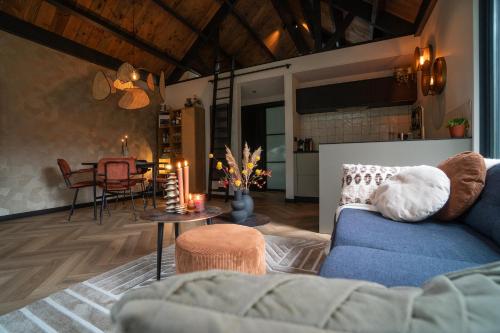 Fantastisch luxe boshuis I Onthaasten in de natuur في إمست: غرفة معيشة مع أريكة زرقاء وطاولة
