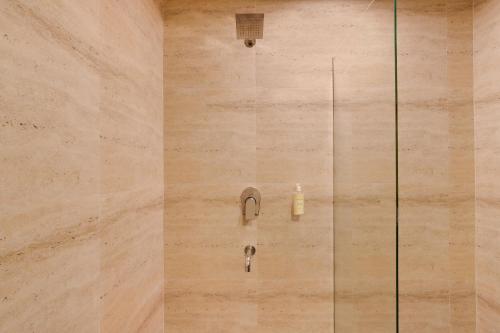 a shower with a faucet and a sink at Lemon Tree Hotel, Dapoli in Dapoli