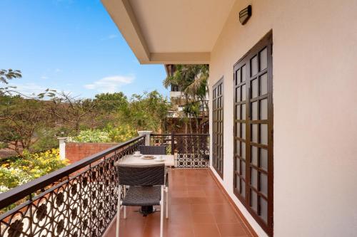 a balcony of a house with a table and chairs at Lemon Tree Hotel, Dapoli in Dapoli