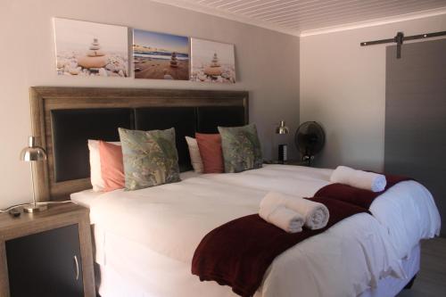 a bedroom with a large white bed with towels on it at Berry Lane Guesthouse in Kroonstad