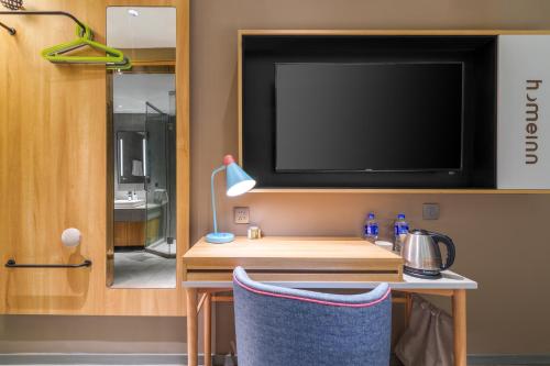 a room with a tv and a table with a chair at Home Inn Zhangjiajie Tianmen Mountain Branch in Zhangjiajie