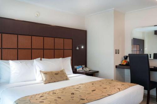 Habitación de hotel con cama grande y escritorio. en Sleep Inn Puebla Centro Hist rico, en Puebla
