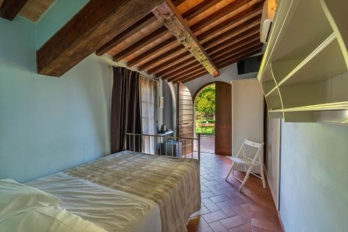 ein Schlafzimmer mit einem Bett in einem Zimmer mit einem Fenster in der Unterkunft Casale San Rufino D'Arce in Assisi