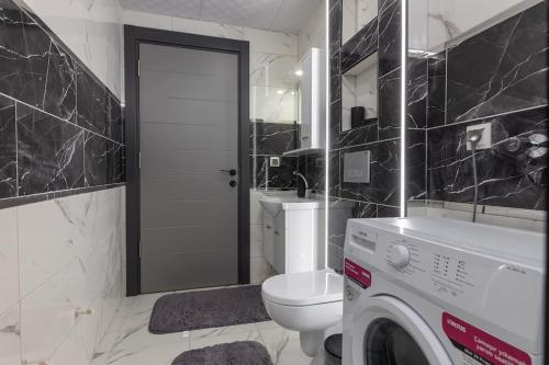 un bagno con WC e lavatrice di 6-Şehir Merkezinde Büyük Modern Daire a Antalya (Adalia)