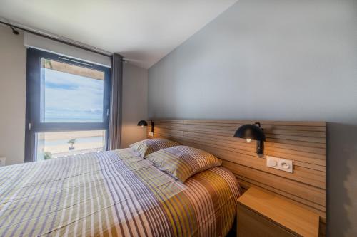 Un dormitorio con una cama y una ventana grande. en Résidence Le Rêve Apt 209, en La Tranche-sur-Mer