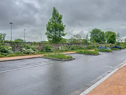 an empty parking lot with a tree in the middle at Maison sur l'eau avec jardin et piscine in Bellerive-sur-Allier